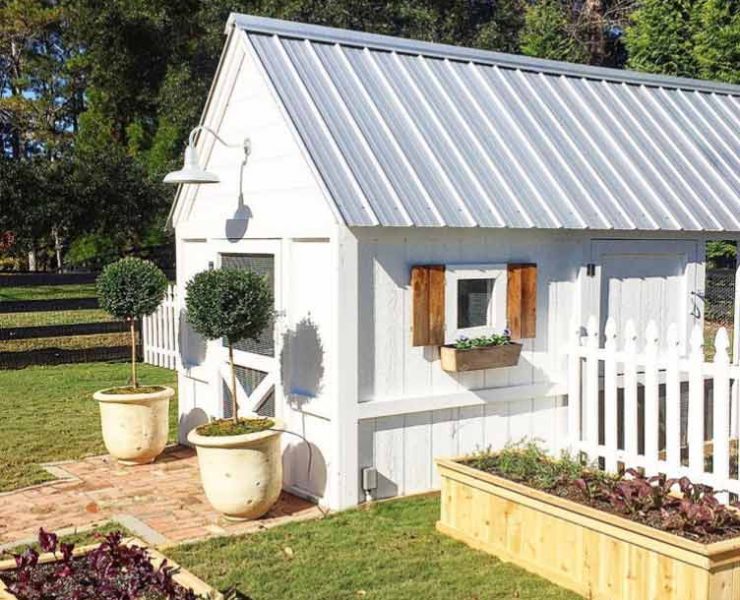 white chicken coop with seam metal roof and window boxes