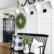 A white foyer with wreaths in a custom farmhouse