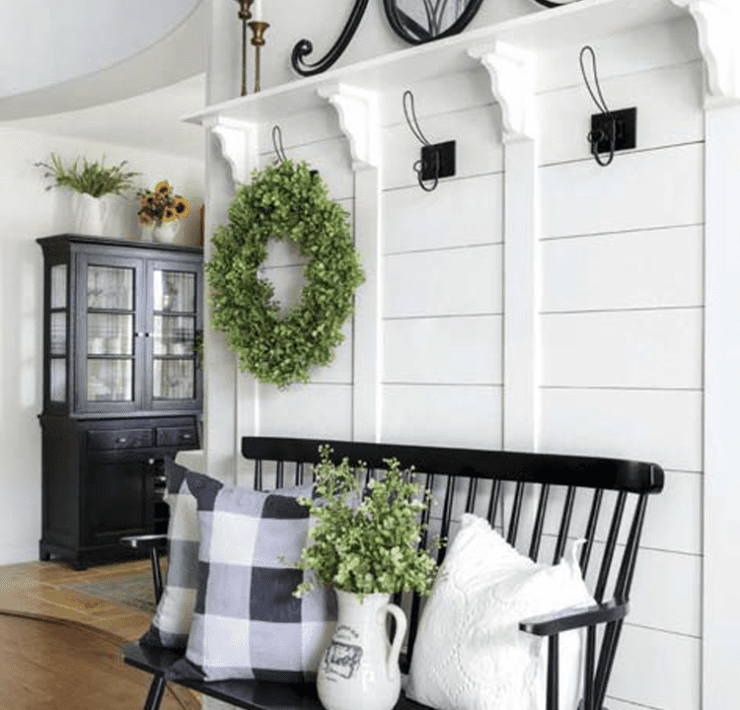 A white foyer with wreaths in a custom farmhouse