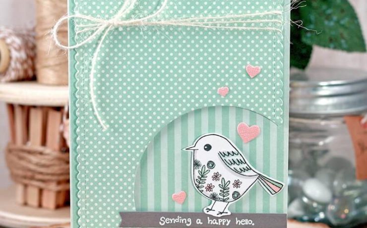 Dotted birthday cards wrapped in twine, complete with a circular striped cutout that contains a bird and a sign saying “sending a happy hello”
