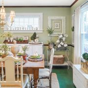 dining room with farmhouse table and green walls in flea market inspired farmhouse