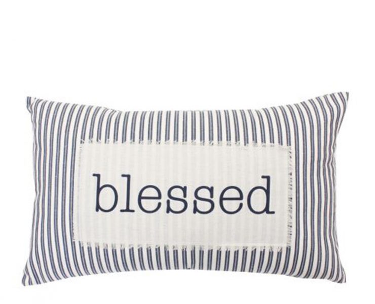 White and navy blue striped rectangular pillow with "blessed" stitched onto a white patch.
