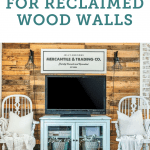 A reclaimed wood wall behind two chairs and a tv