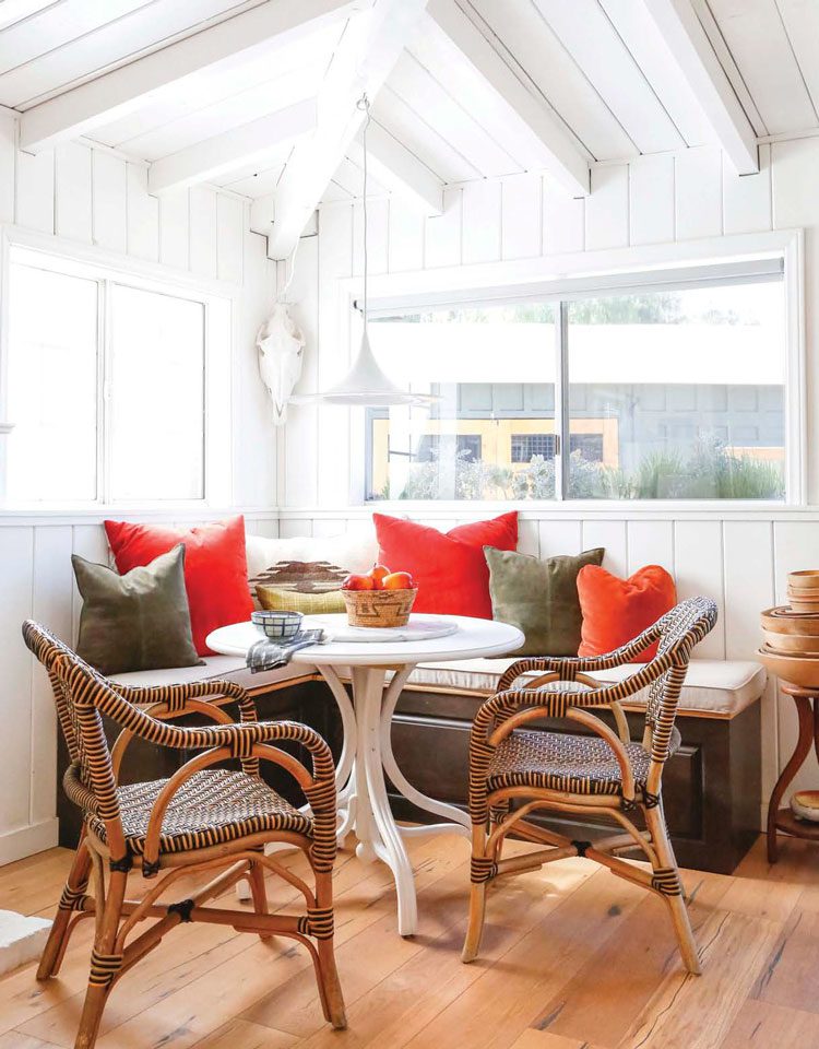 bright dining nook with built in bench and white table in ranch renovation