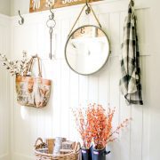 Nina's mudroom uses everyday items to create a chic upcycled fall look. She has a flannel hanging by a hook above rain boots-turned planters and a woven basket.