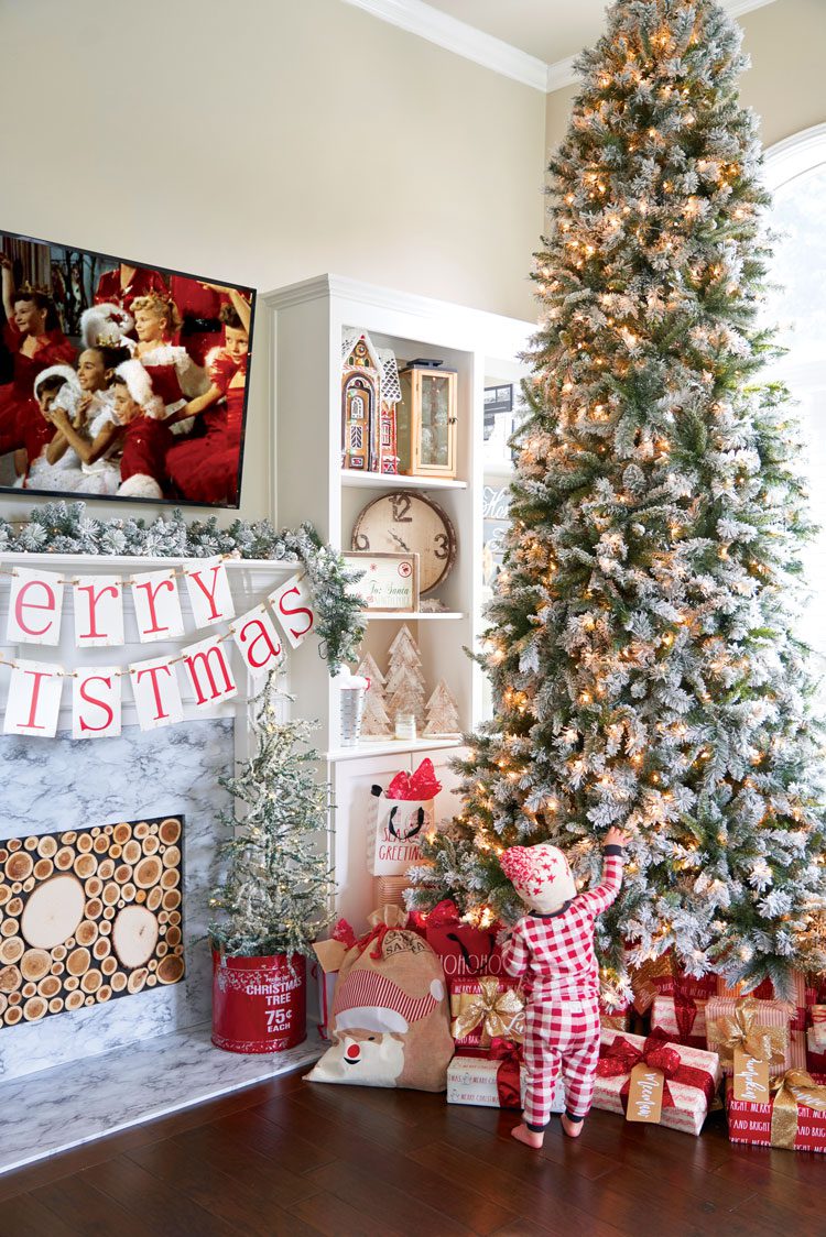 Jenna's toddler looks up at her lit, snow crusted Christmas tree.