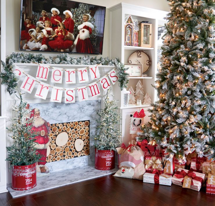 Jenna's toddler looks up at her lit, snow crusted Christmas tree in their family friendly Christmas house.