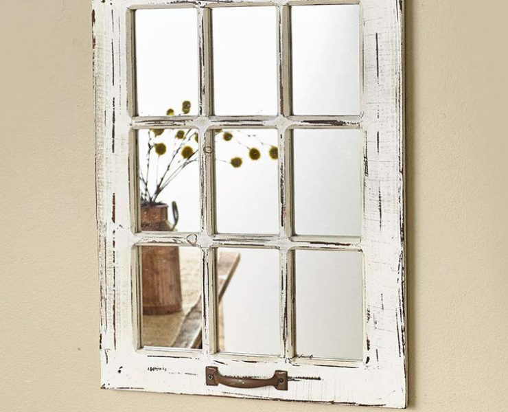 Cream-colored and vintage-inspired window frame with mirror pieces in each rectangle.
