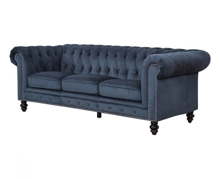 This piece of farmhouse furniture is a three-cushion, tufted, ark blue couch with curved armrests.