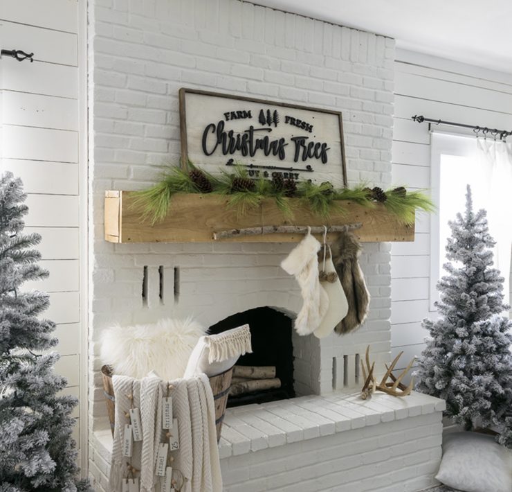 Jo's fireplace with her DIY stocking holder—a thin birch branch hanging from the mantel with faux fur stockings.