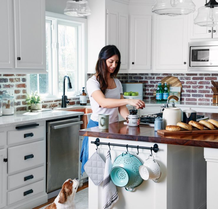 A woman makes coffee in a modern farmhouse kitchen