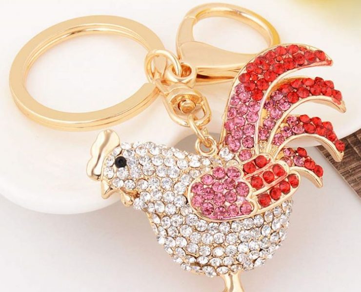 A rooster keychain bedazzled in white, red, and pink crystals