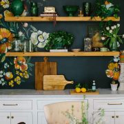 Kitchen with floral pattern on walls above open shelves