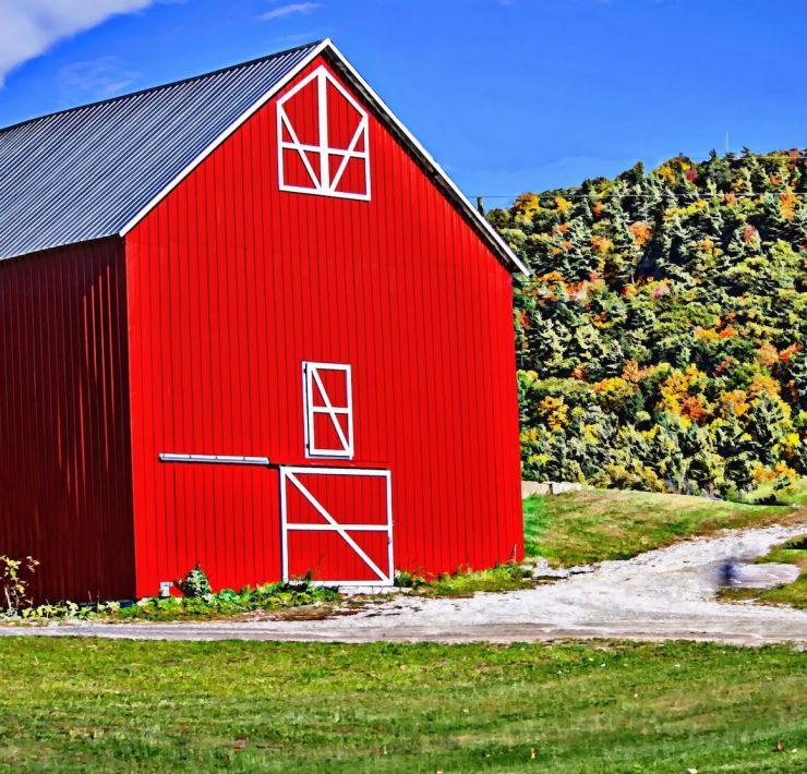 red barn with green hills in the background