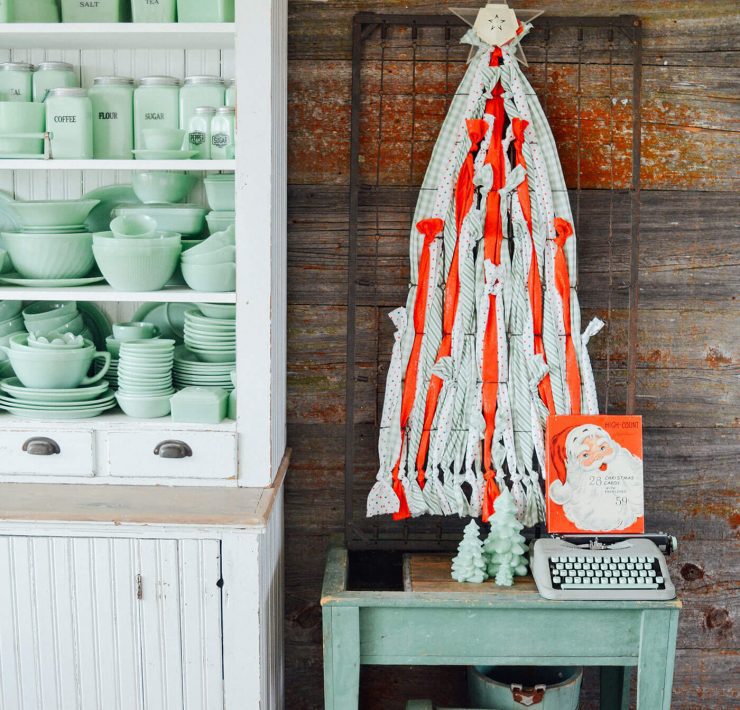 DIY Christmas tree decoration next to cupboard with jadite