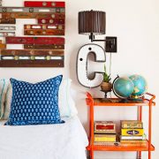 Bedroom with old bar cart as nightstand and vintage levels as headboard