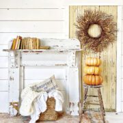 chippy mantel against white wall with pumpkins and other fall decor