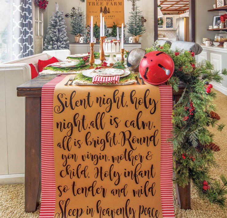 Dining table with Christmas garland, sign art and set table