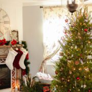 Christmas tree next to mantel with red and white stockings