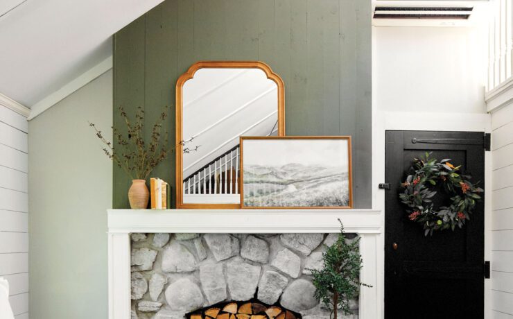 Living room with gren and mantel and cozy decor with a vintage mirror