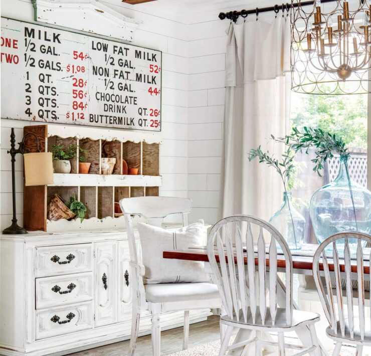 neutral colored dining room with old furniture and exposed ceiling beams